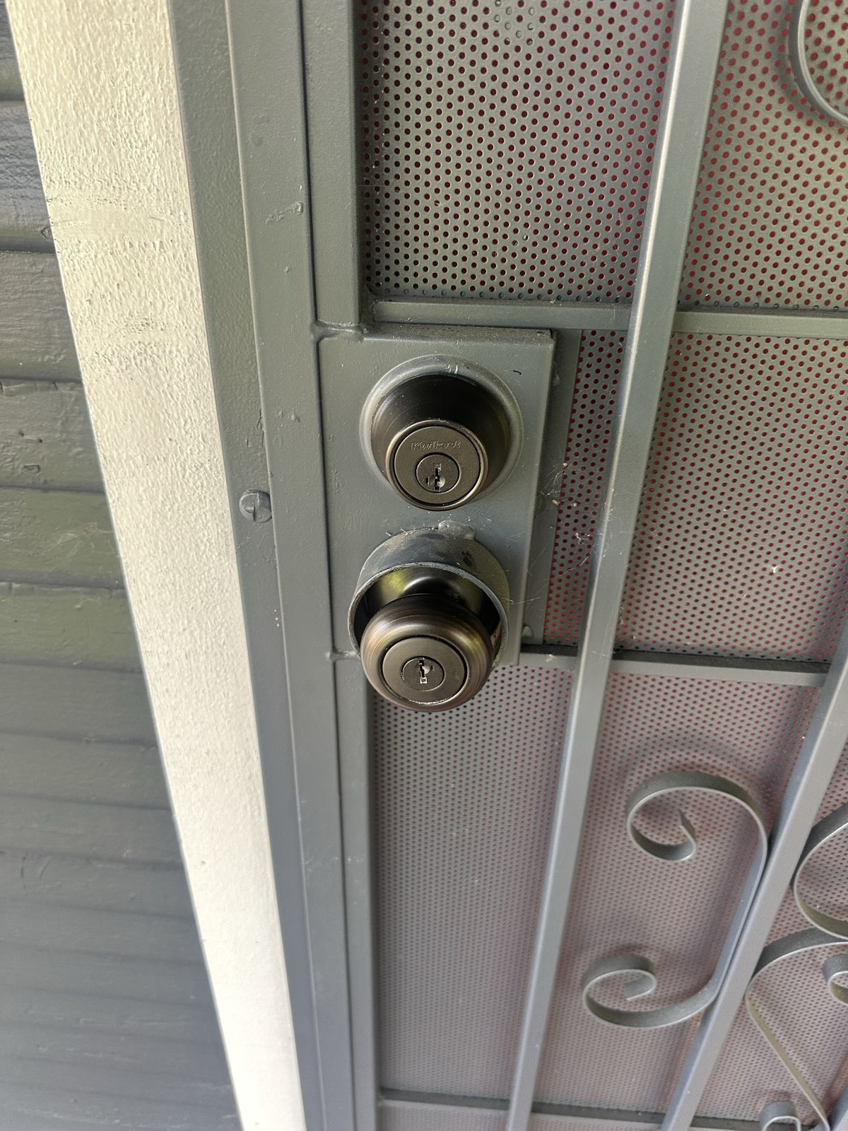 Two keyed locks on a security screen door in Sacramento