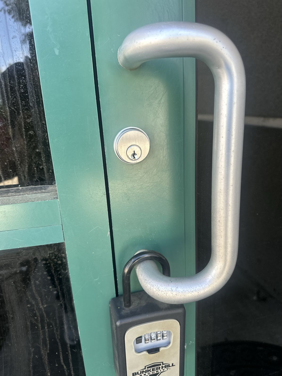 Storefront door with a pull handle, key cylinder, and lockbox in Sacramento
