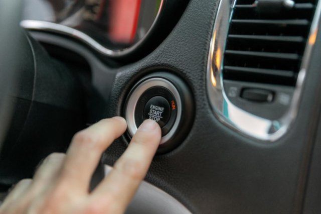 Finger pressing a car's push-to-start button in Sacramento