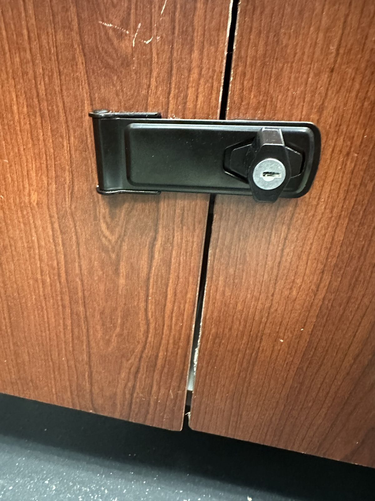 Keyed hasp lock securing a wooden cabinet in Sacramento