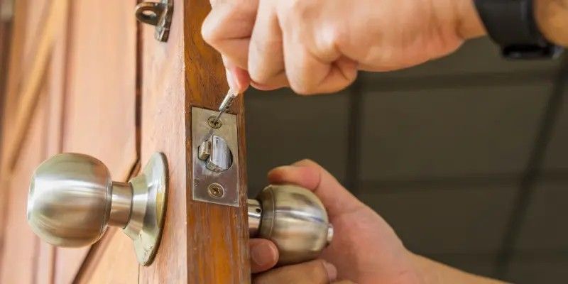 Flat Price Locksmith technician installing a doorknob and latch on a front door in Sacramento